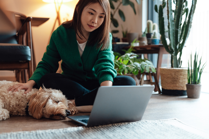 Woman sitting on floor looking at laptop